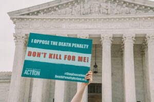 Death penalty opponent holds sign in front of government building