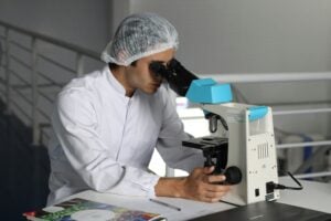 scientist looks at hair under microscope